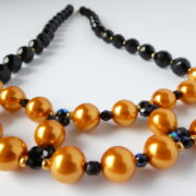 Le tissage des perles en verre du collier Inès or et noir.