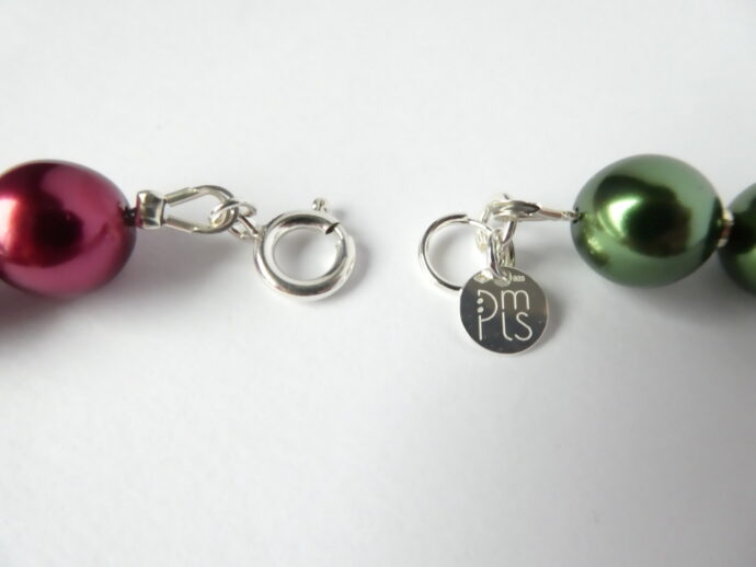La marque PMLS et le fermoir du collier Romy vert et violet.