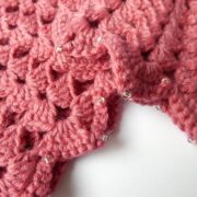 Détail des coquilles et des perles des manchettes roses.