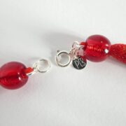 La marque et le fermoir du collier rouge Rudy sont en argent 925.