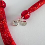 Gros plan sur la résille tubulaire rouge du collier Rudy.